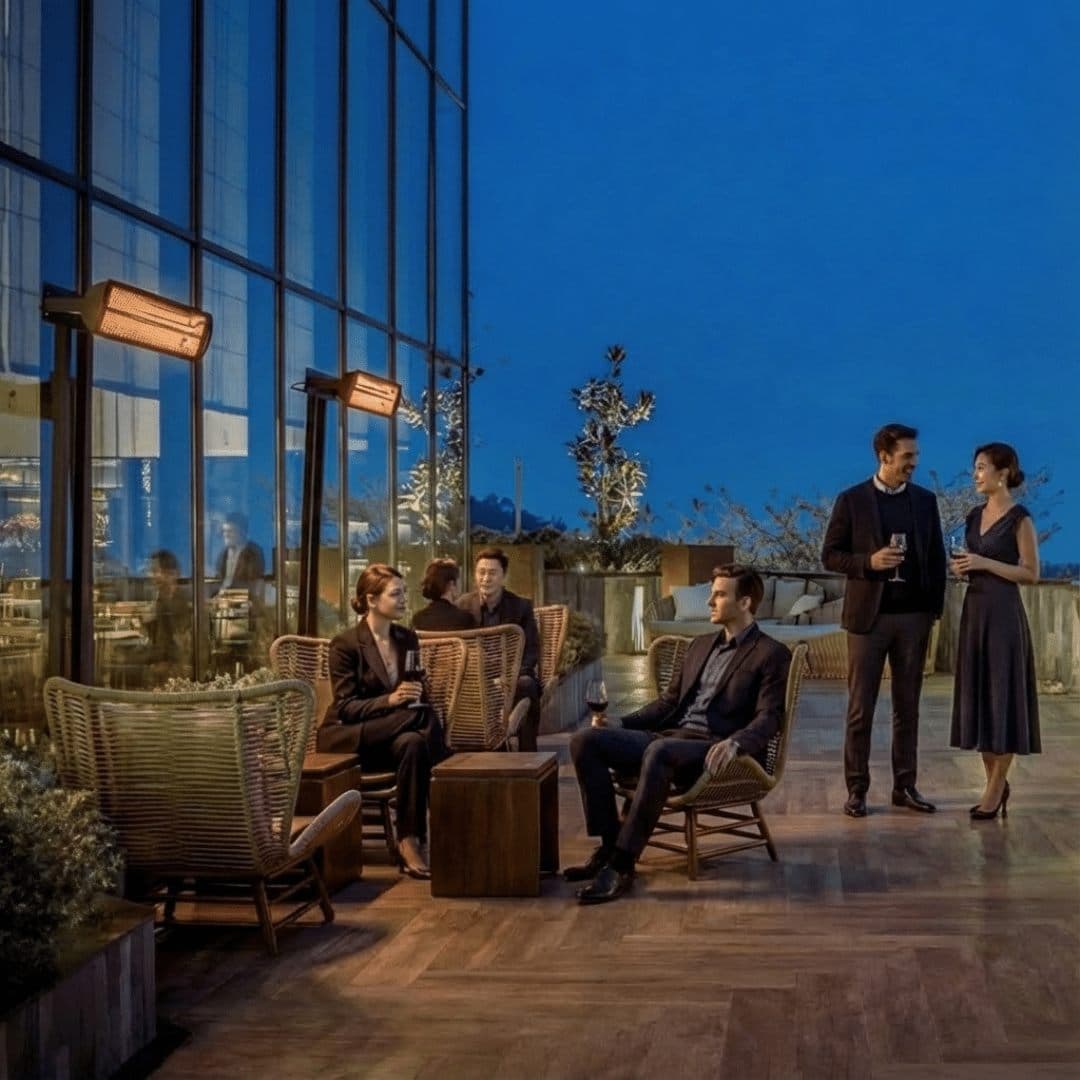 Pole-mounted Bromic Tungsten heaters warming a rooftop terrace at dusk