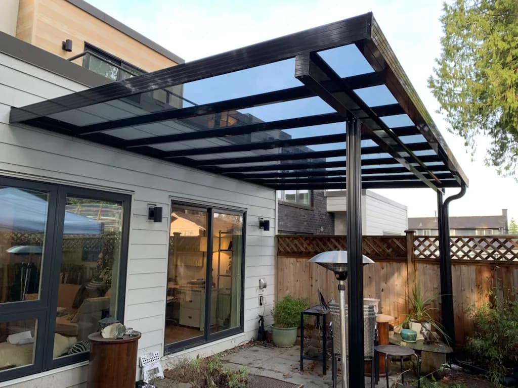 Dark framed glass patio cover over a residential terrace
