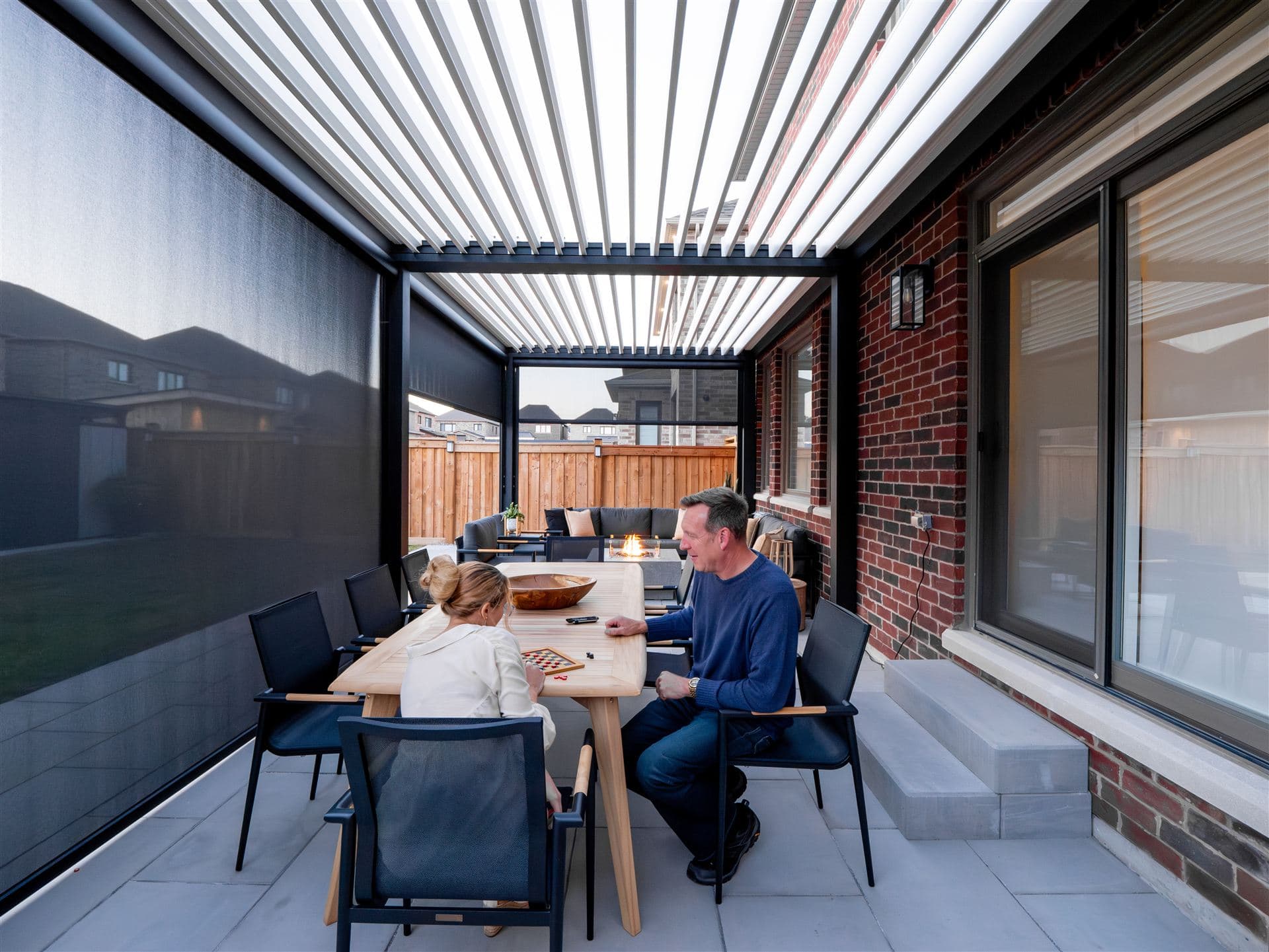 Under a LOUSOL louvered roof with open louvers and zip screens