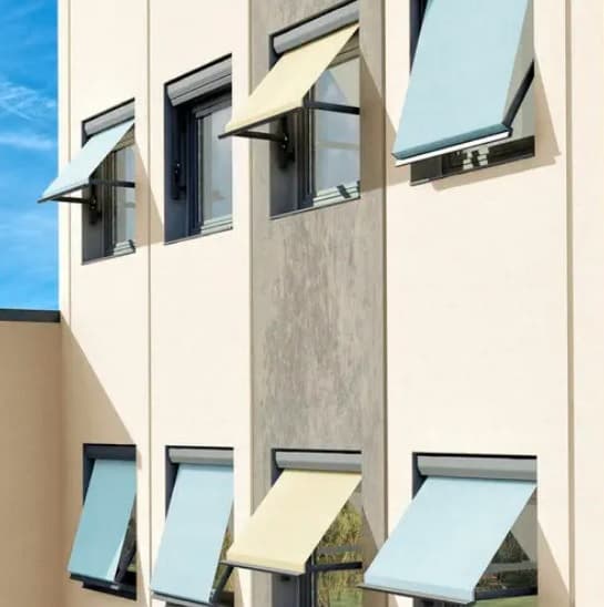 Drop arm shade extended at angle over residential window